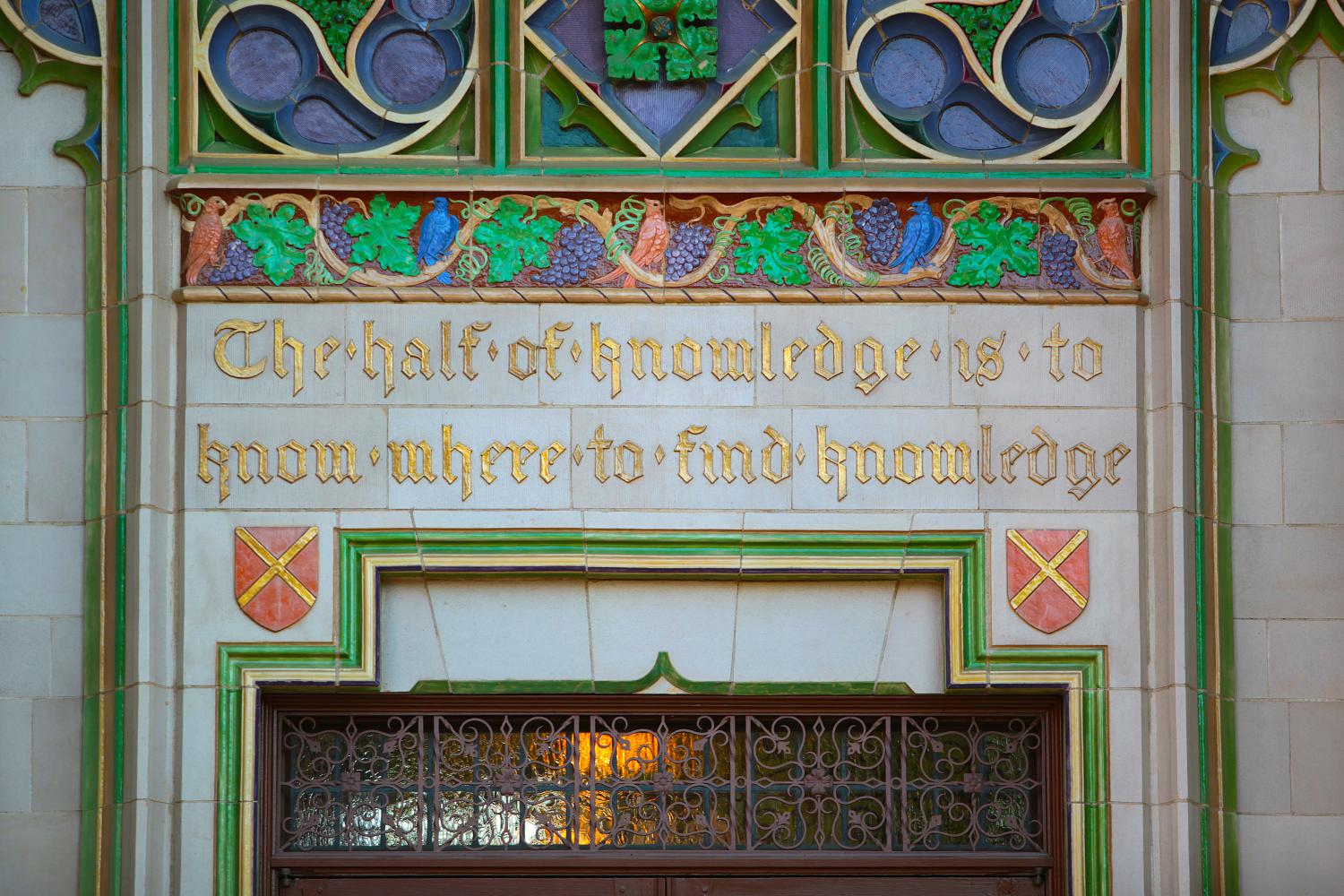 A golden inscription framed by artwork of songbirds and grapevines reads "The half of knowledge is to know where to find knowledge."