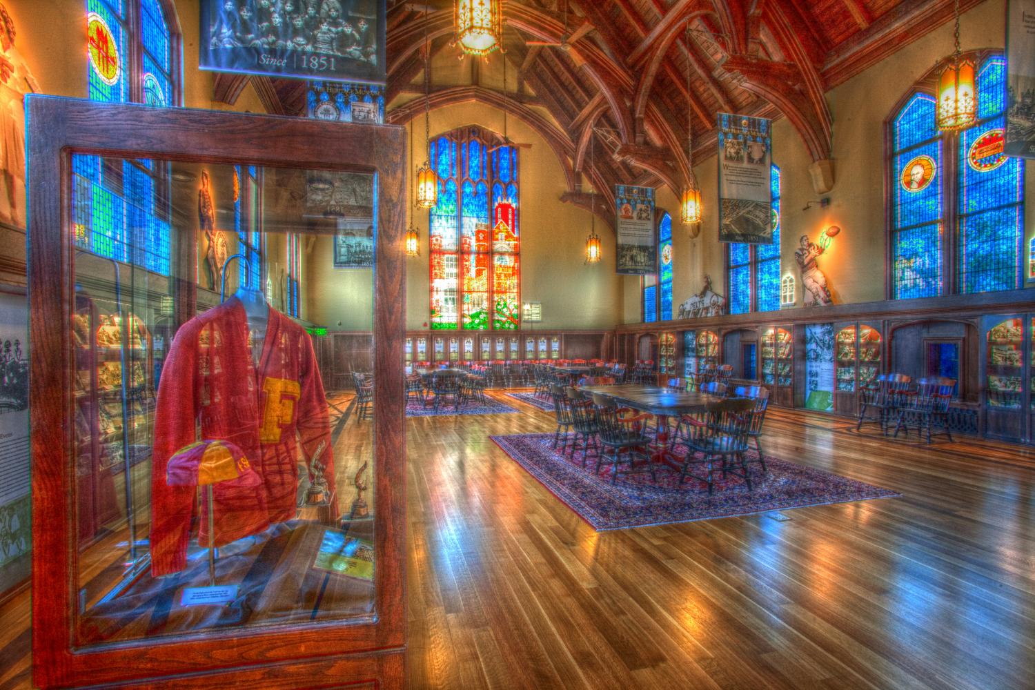Sunlight filters through the intricate, multicolored stained glass of Dodd Hall's Werkmeister Reading Room, home of the Heritage Museum. The light reflects off of the smooth hardwood floors.